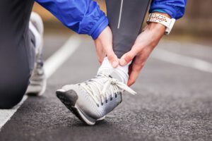 Frau knickt mit dem Fuß um: Häufige Ursache für einen Bänderriss am Sprunggelenk